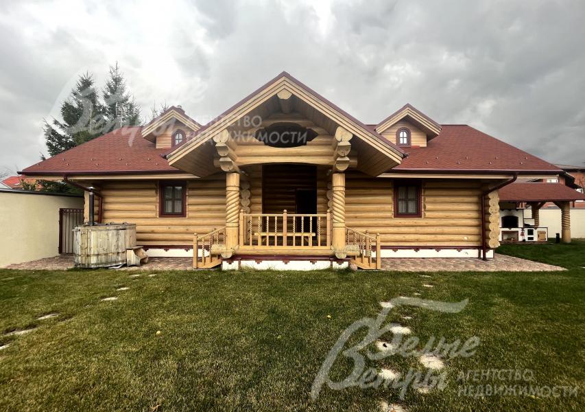 На участке построена баня с гостевой спальней и террасой, у бани стоит чан (бочка)