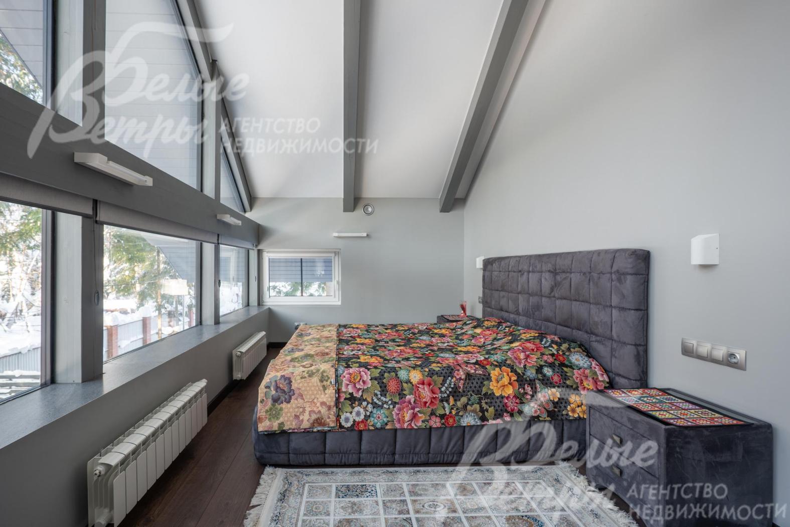 Спальня мастер-блока на втором этаже с панорамным остеклением и высокими потолками