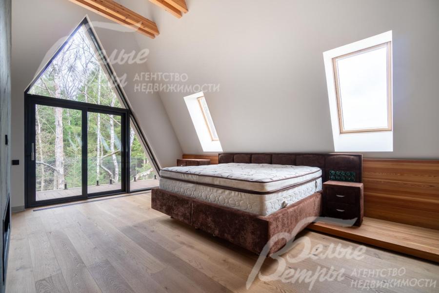 Мастер-спальня на втором этаже дома - с выходом на балкон и тремя мансардными окнами