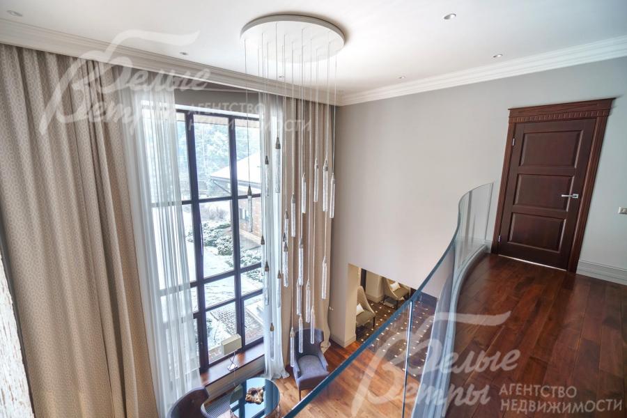 Прозрачное изогнутое ограждение и люстра продуманного дизайна позволяют без препятствий видеть лес.